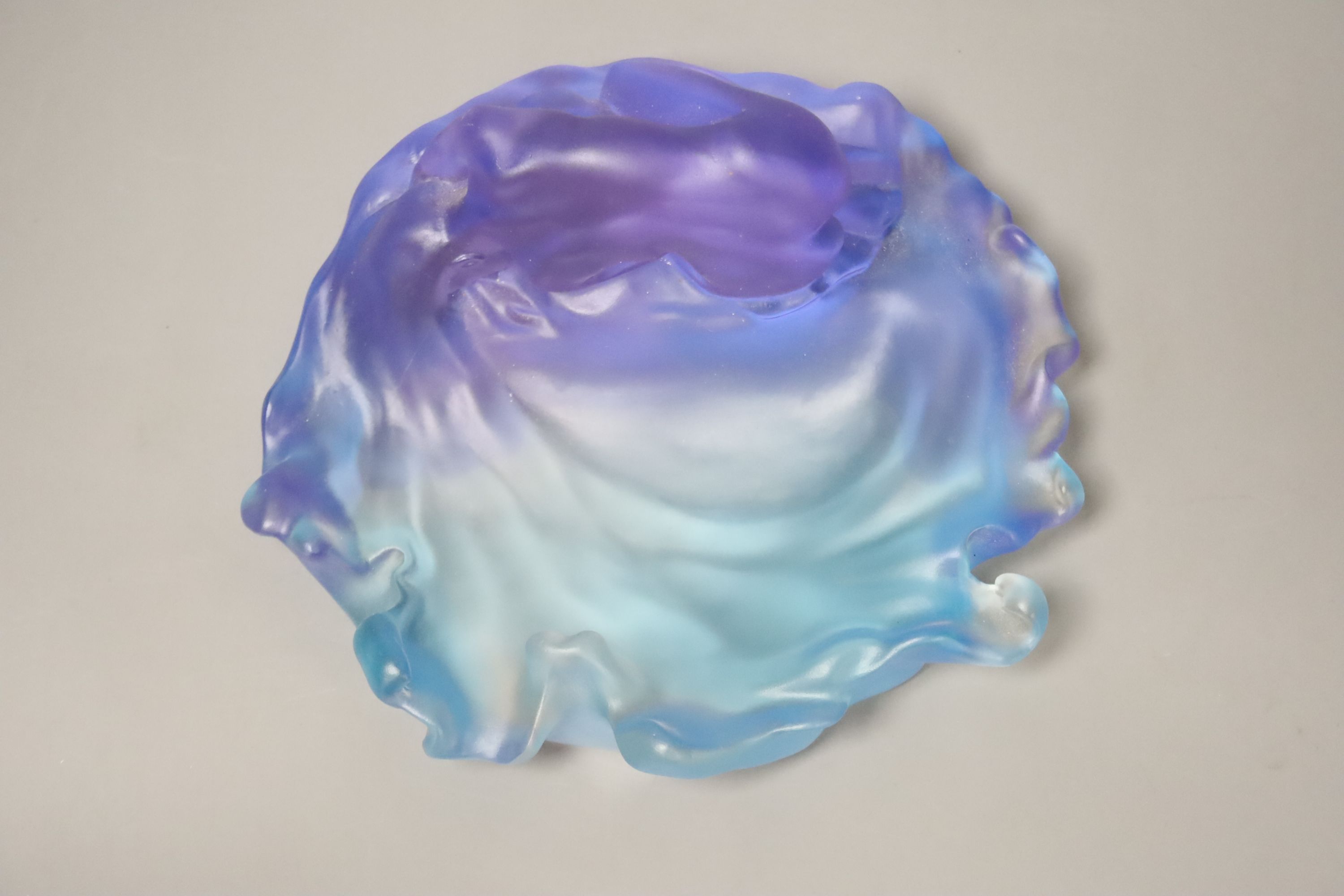 A blue and lilac glass dish with a kneeling nude, apocryphal Daum mark 18cm long